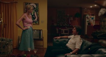 Movie still from “American Made” (2017), directed by Doug Liman – A man and a woman sitting on a couch in a living room; Medium shot, Over the shoulder angle