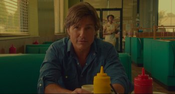 Movie still from “American Made” (2017), directed by Doug Liman – A man sitting at a table with a cup of coffee; Close Up shot, Over the shoulder angle