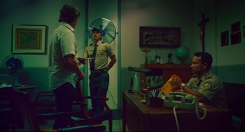Movie still from “American Made” (2017), directed by Doug Liman – Two men are standing in a living room; Medium shot, Over the shoulder angle