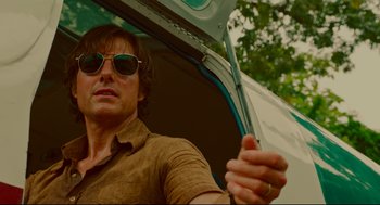 Movie still from “American Made” (2017), directed by Doug Liman – A person wearing sunglasses and holding an umbrella; Close Up shot, Low angle