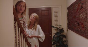 Movie still from “American Made” (2017), directed by Doug Liman – A woman standing next to a young girl on a staircase; Medium shot, Over the shoulder angle