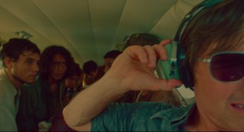 Movie still from “American Made” (2017), directed by Doug Liman – A person holding a cell phone in their hand; Close Up shot, Over the shoulder angle