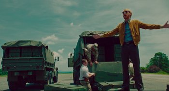 Movie still from “American Made” (2017), directed by Doug Liman – A man standing on the back of a military vehicle; Wide shot, Low angle