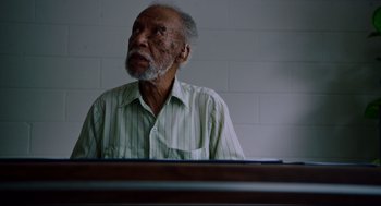 Movie still from “American Made” (2017), directed by Doug Liman – An older man sitting in front of a table; Close Up shot, Low angle
