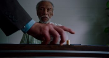Movie still from “American Made” (2017), directed by Doug Liman – An older man playing a game of domino with an older man; Close Up shot, High angle