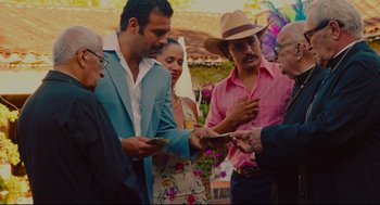 Movie still from “American Made” (2017), directed by Doug Liman – A group of people standing around each other; Medium shot, Over the shoulder angle