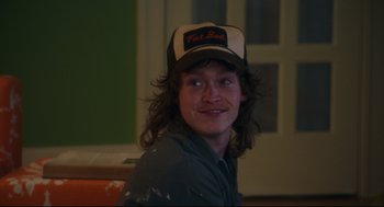 Movie still from “American Made” (2017), directed by Doug Liman – A young man with long brown hair wearing a hat; Close Up shot, Over the shoulder angle