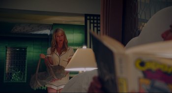 Movie still from “American Made” (2017), directed by Doug Liman – A woman is holding a bag in front of a mirror; Medium shot, Over the shoulder angle