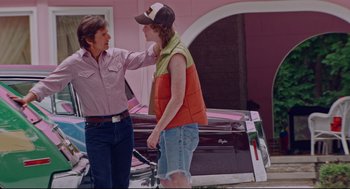 Movie still from “American Made” (2017), directed by Doug Liman – Two men standing next to each other in front of a car; Medium shot, Over the shoulder angle