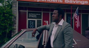 Movie still from “American Made” (2017), directed by Doug Liman – A man in a suit leaning on the side of a car; Medium shot, Low angle