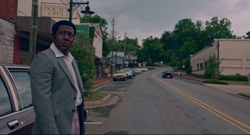 Movie still from “American Made” (2017), directed by Doug Liman – A man standing on the side of a road; Medium shot, Over the shoulder angle