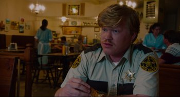 Movie still from “American Made” (2017), directed by Doug Liman – A man in a uniform eating food in a restaurant; Medium shot, Over the shoulder angle