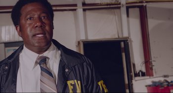 Movie still from “American Made” (2017), directed by Doug Liman – A man in a tie and jacket standing in front of a wall; Close Up shot, Low angle