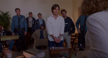 Movie still from “American Made” (2017), directed by Doug Liman – A group of men standing around a table; Medium shot, Over the shoulder angle
