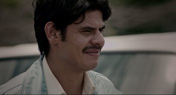 Movie still from “American Made” (2017), directed by Doug Liman – A person with a mustache smiling; Close Up shot, Over the shoulder angle