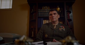 Movie still from “American Made” (2017), directed by Doug Liman – A man in uniform sitting at a table; Medium shot, Low angle