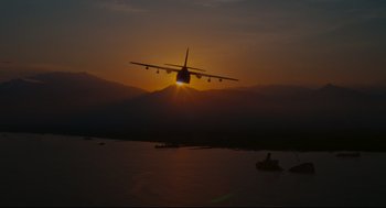 Movie still from “American Made” (2017), directed by Doug Liman – An airplane is flying low over a body of water at sunset; Extreme Wide shot, Low angle