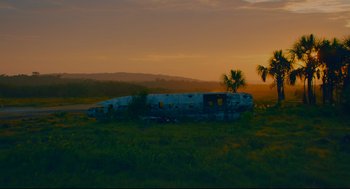 Movie still from “American Made” (2017), directed by Doug Liman – An old plane sitting in the middle of a grassy field; Extreme Wide shot, Low angle