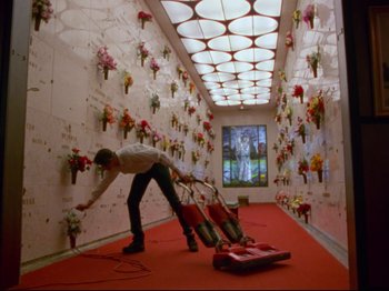 A man is vacuuming the floor of a room