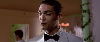 Movie still from “American Psycho” (2000), directed by Mary Harron – A person wearing a suit and a bow tie; Close Up shot, Low angle