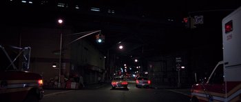 Movie still from “American Psycho” (2000), directed by Mary Harron – Cars parked on the side of the road at night; Extreme Wide shot, Low angle