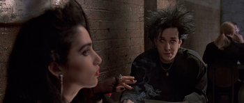 Movie still from “American Psycho” (2000), directed by Mary Harron – A woman sitting in front of a mirror smoking a cigarette; Medium shot, Over the shoulder angle