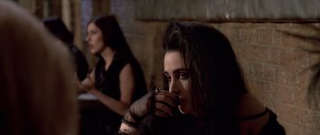 Movie still from “American Psycho” (2000), directed by Mary Harron – A woman with long dark hair and a black dress; Close Up shot, Over the shoulder angle