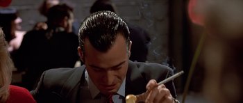 Movie still from “American Psycho” (2000), directed by Mary Harron – A man in a business suit eating a donut; Close Up shot, Low angle
