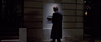 Movie still from “American Psycho” (2000), directed by Mary Harron – A man standing in front of an atm machine at night; Wide shot, Low angle