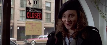 Movie still from “American Psycho” (2000), directed by Mary Harron – A woman standing in front of a closed store window; Close Up shot, Over the shoulder angle