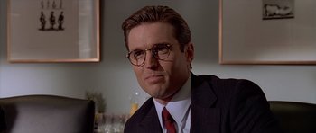 Movie still from “American Psycho” (2000), directed by Mary Harron – A person wearing glasses and a suit; Close Up shot, Low angle