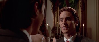 Movie still from “American Psycho” (2000), directed by Mary Harron – A man in a suit is talking to a woman; Close Up shot, Over the shoulder angle