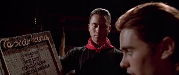 Movie still from “American Psycho” (2000), directed by Mary Harron – A man in a black shirt and a red bandanna; Close Up shot, Low angle