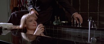 Movie still from “American Psycho” (2000), directed by Mary Harron – A woman sitting in front of a bathroom mirror; Medium shot, High angle