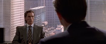 Movie still from “American Psycho” (2000), directed by Mary Harron – Two men in business suits in front of a city skyline; Medium shot, Over the shoulder angle