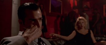 Movie still from “American Psycho” (2000), directed by Mary Harron – A man sitting in front of a woman in front of a mirror; Close Up shot, Low angle