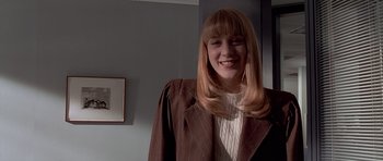 Movie still from “American Psycho” (2000), directed by Mary Harron – A woman with blonde hair wearing a brown jacket; Medium shot, Low angle