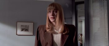 Movie still from “American Psycho” (2000), directed by Mary Harron – A woman with long blonde hair wearing a brown jacket; Close Up shot, Low angle
