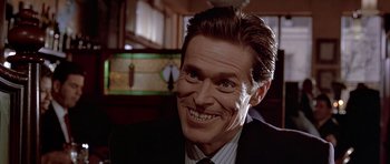 Movie still from “American Psycho” (2000), directed by Mary Harron – A man that is smiling and has no makeup on his face; Close Up shot, Over the shoulder angle