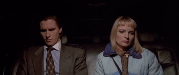 Movie still from “American Psycho” (2000), directed by Mary Harron – A man and a woman sitting next to each other in the back of a car; Close Up shot, Low angle