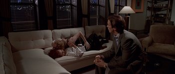 Movie still from “American Psycho” (2000), directed by Mary Harron – A man and a woman sitting on a white couch; Medium shot, High angle