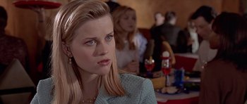 Movie still from “American Psycho” (2000), directed by Mary Harron – A person sitting in front of other people; Close Up shot, High angle