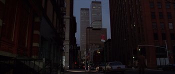 Movie still from “American Psycho” (2000), directed by Mary Harron – A city street at night with tall skyscrapers in the background; Extreme Wide shot, Low angle