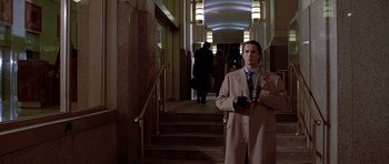 Movie still from “American Psycho” (2000), directed by Mary Harron – A man standing in front of some stairs; Medium shot, Low angle