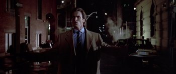 Movie still from “American Psycho” (2000), directed by Mary Harron – A man wearing a suit and tie standing on a street; Medium shot, Low angle