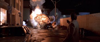 Movie still from “American Psycho” (2000), directed by Mary Harron – A car is being destroyed by a bunch of fireworks; Extreme Wide shot, Low angle