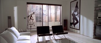 Movie still from “American Psycho” (2000), directed by Mary Harron – A room with two black chairs and a window; Wide shot, High angle
