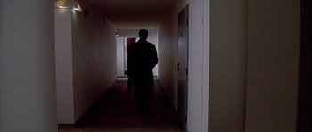 Movie still from “American Psycho” (2000), directed by Mary Harron – A man is walking down the hallway of a building; Wide shot, High angle