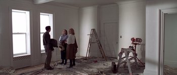 Movie still from “American Psycho” (2000), directed by Mary Harron – Two women are standing in the middle of a room; Wide shot, High angle
