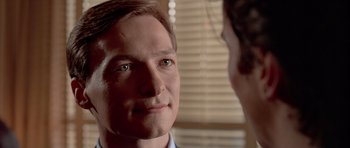 Movie still from “American Psycho” (2000), directed by Mary Harron – A man's face as he stares at another man; Close Up shot, Over the shoulder angle